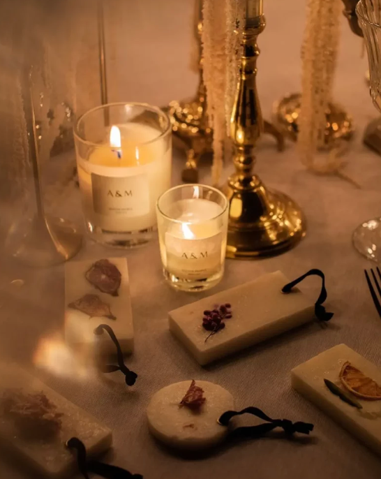 Candlelit table setting with decorative elements on a white tablecloth.
