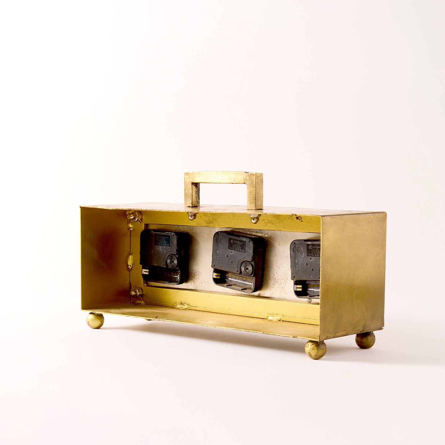 Brass electrical box with three sockets on a white background