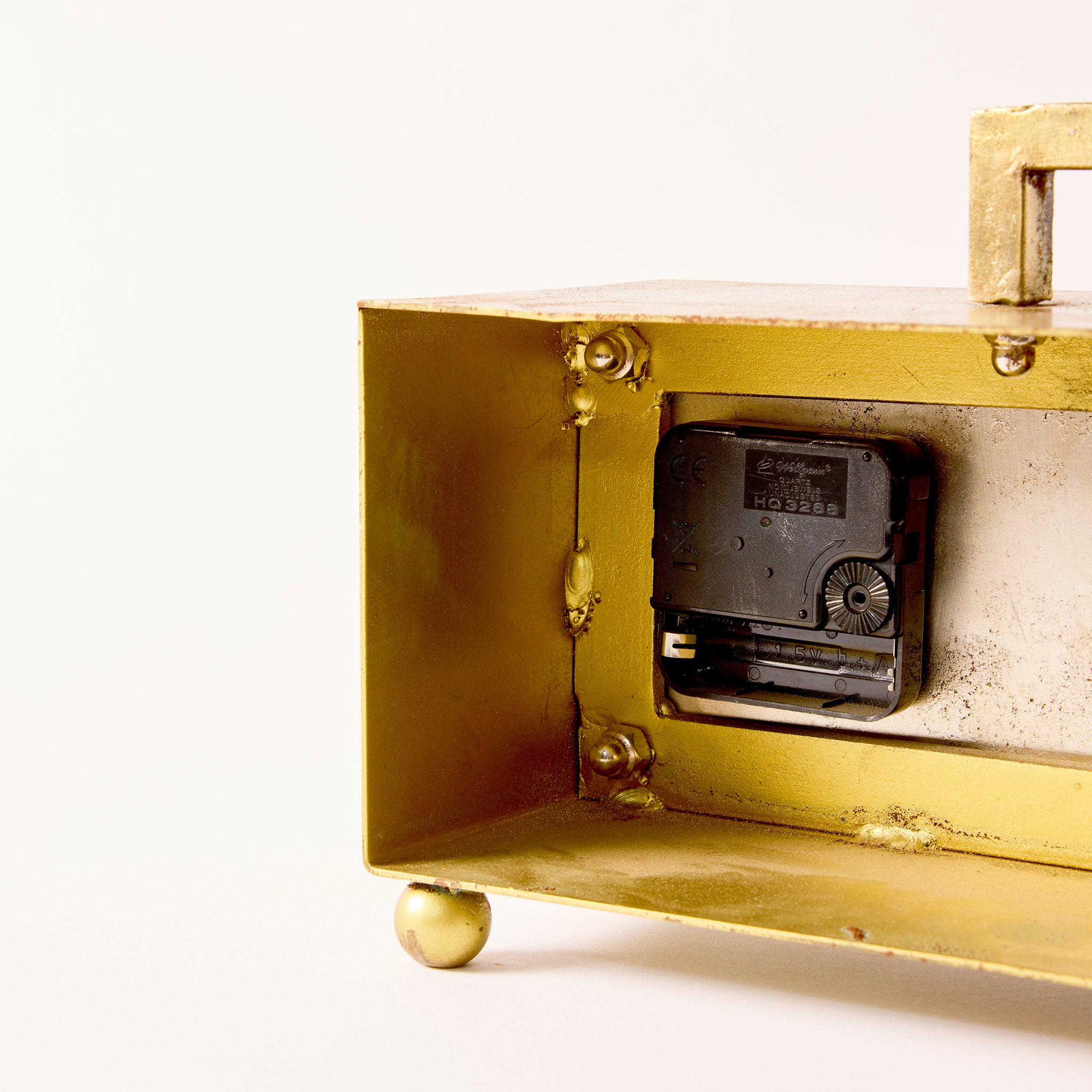 Vintage-style mechanical device with brass casing on a white background