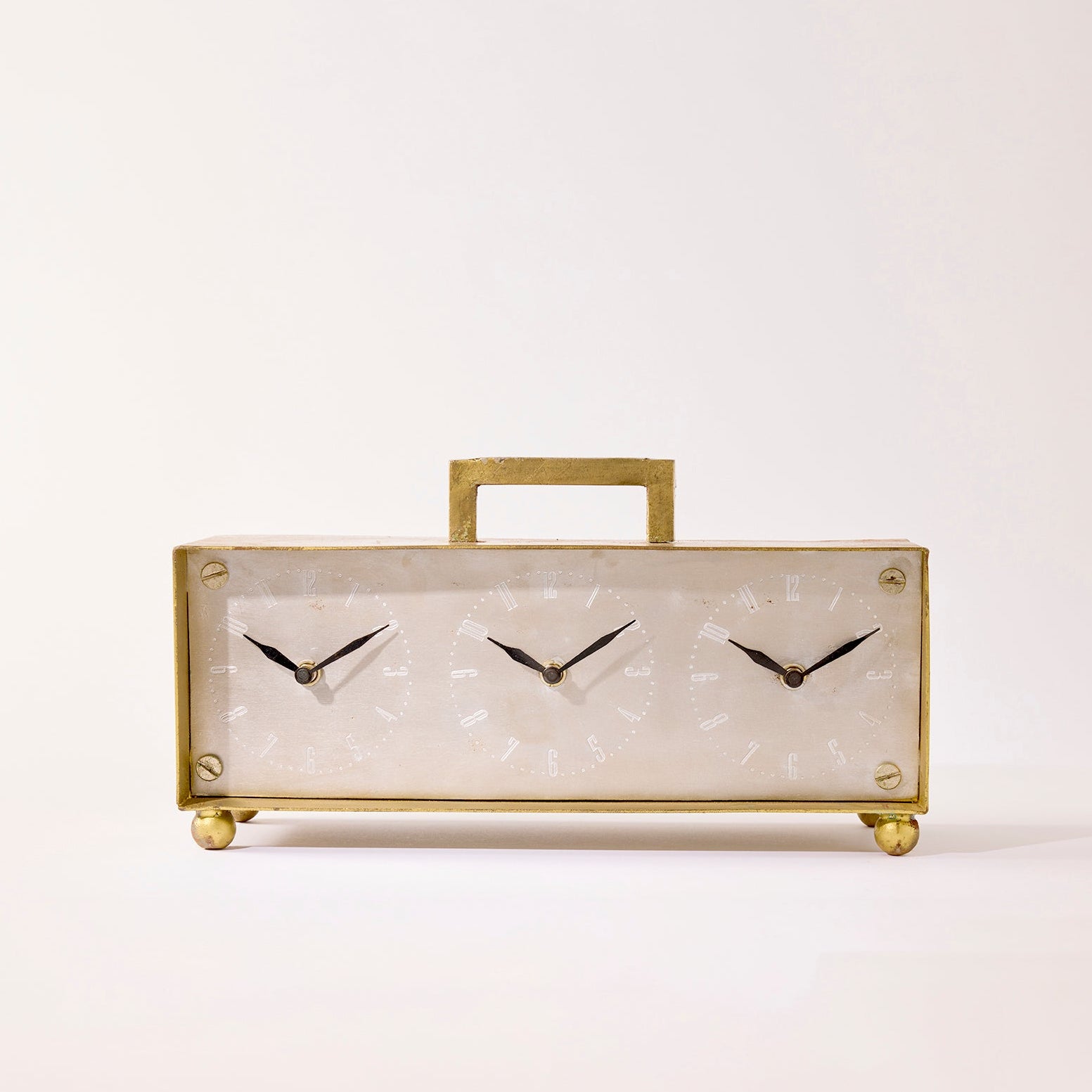 Decorative clock with gold frame and black hands on a light background