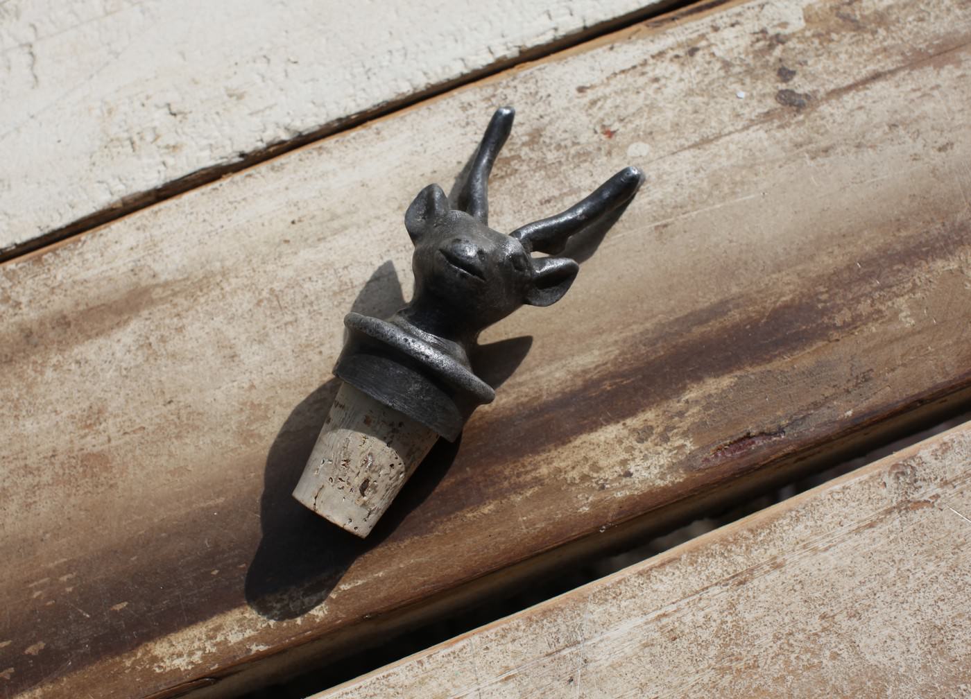 Metallic animal-shaped bottle opener on a wooden surface