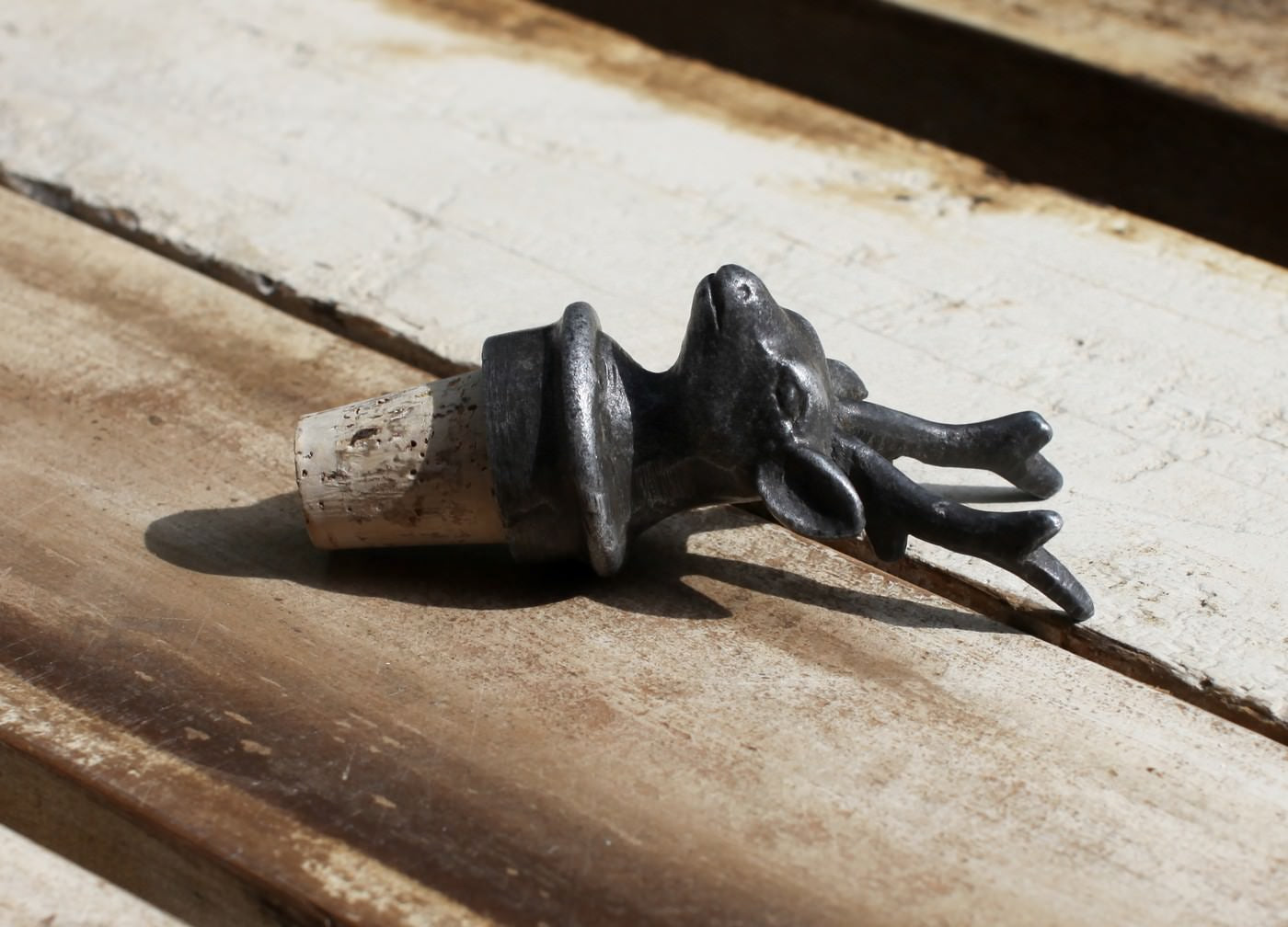 Decorative metal frog sculpture on a wooden surface