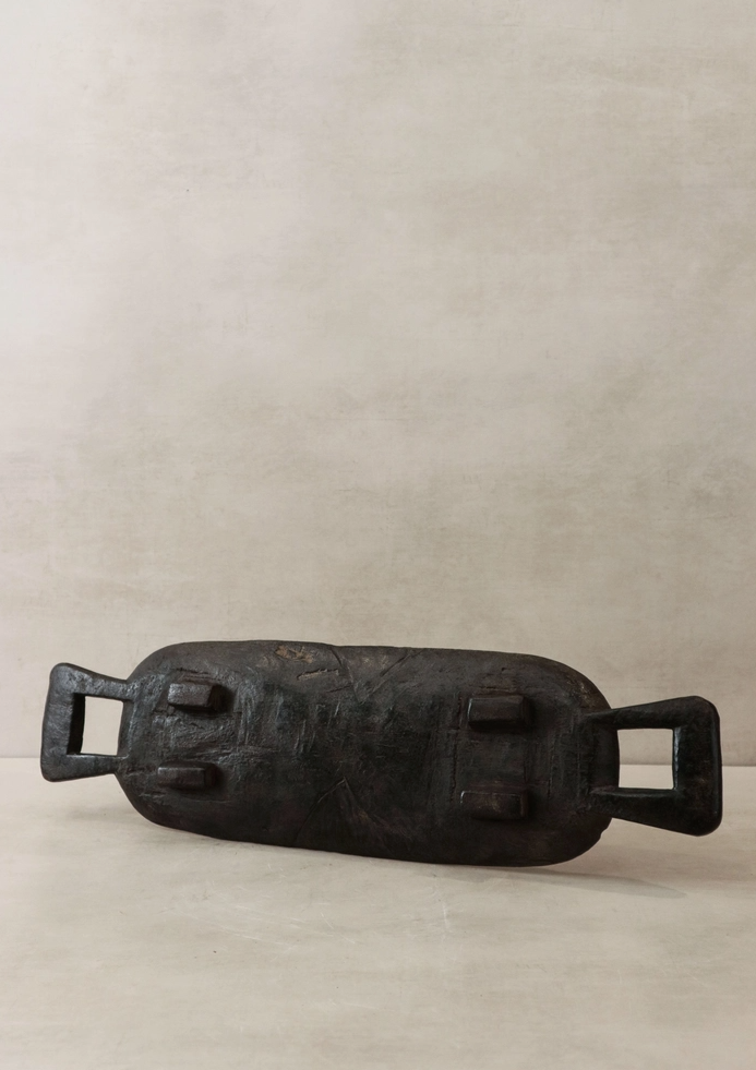 Black metal object on a beige background