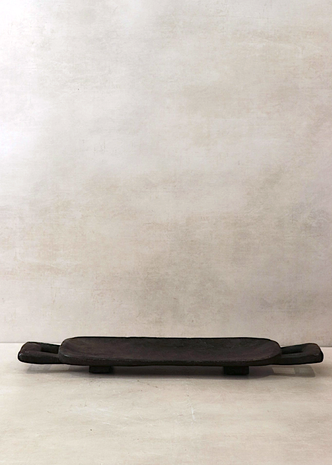 Dark brown wooden tray on a light gray background