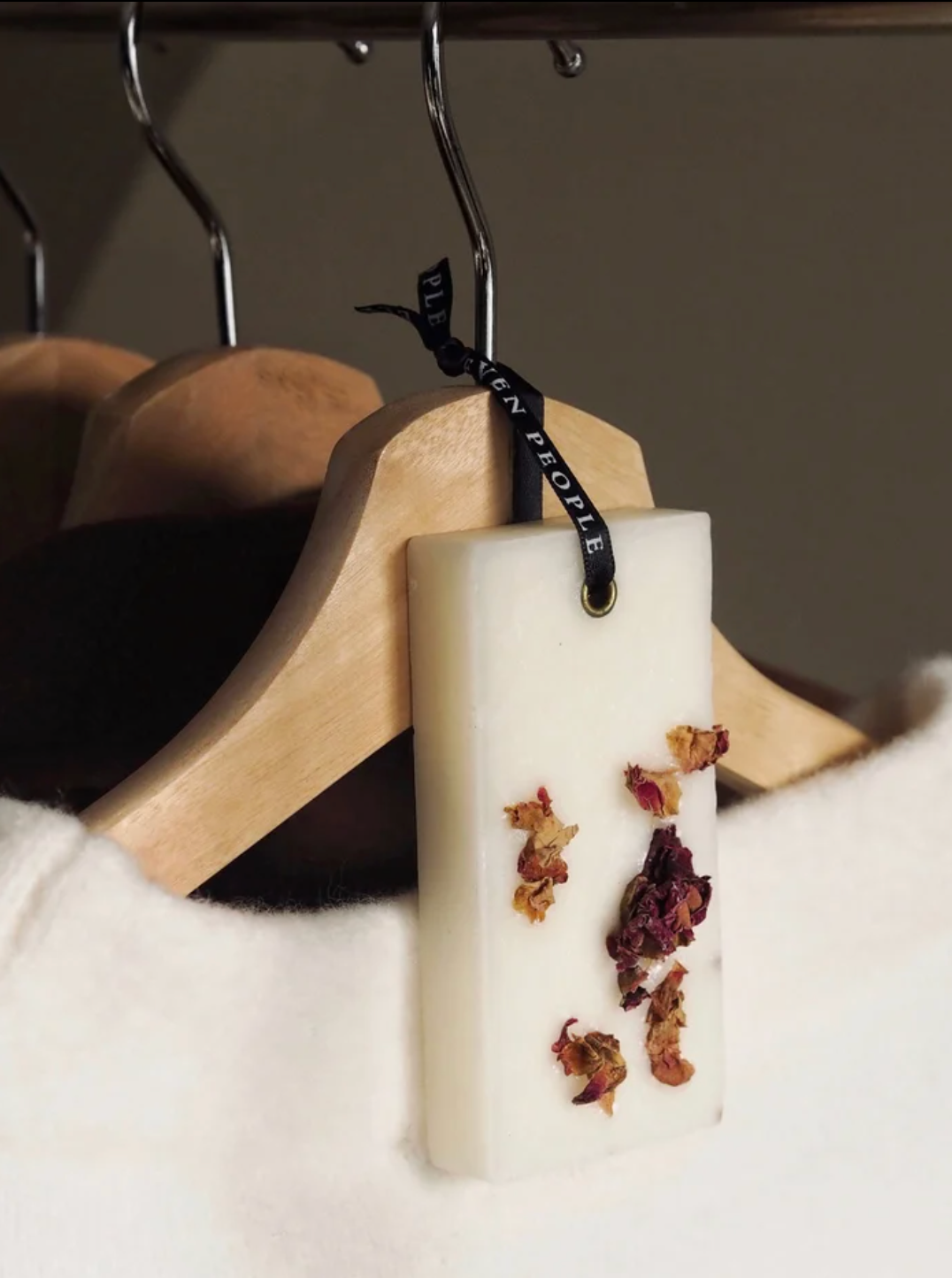 Rectangular white soap with dried flowers on a wooden hanger