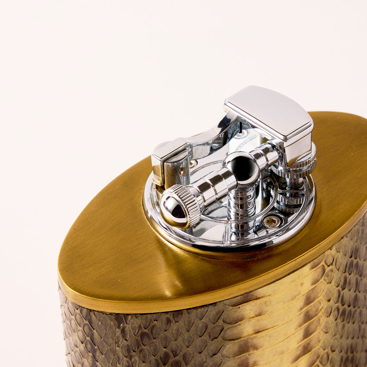 Gold and silver lighter with textured surface on a white background