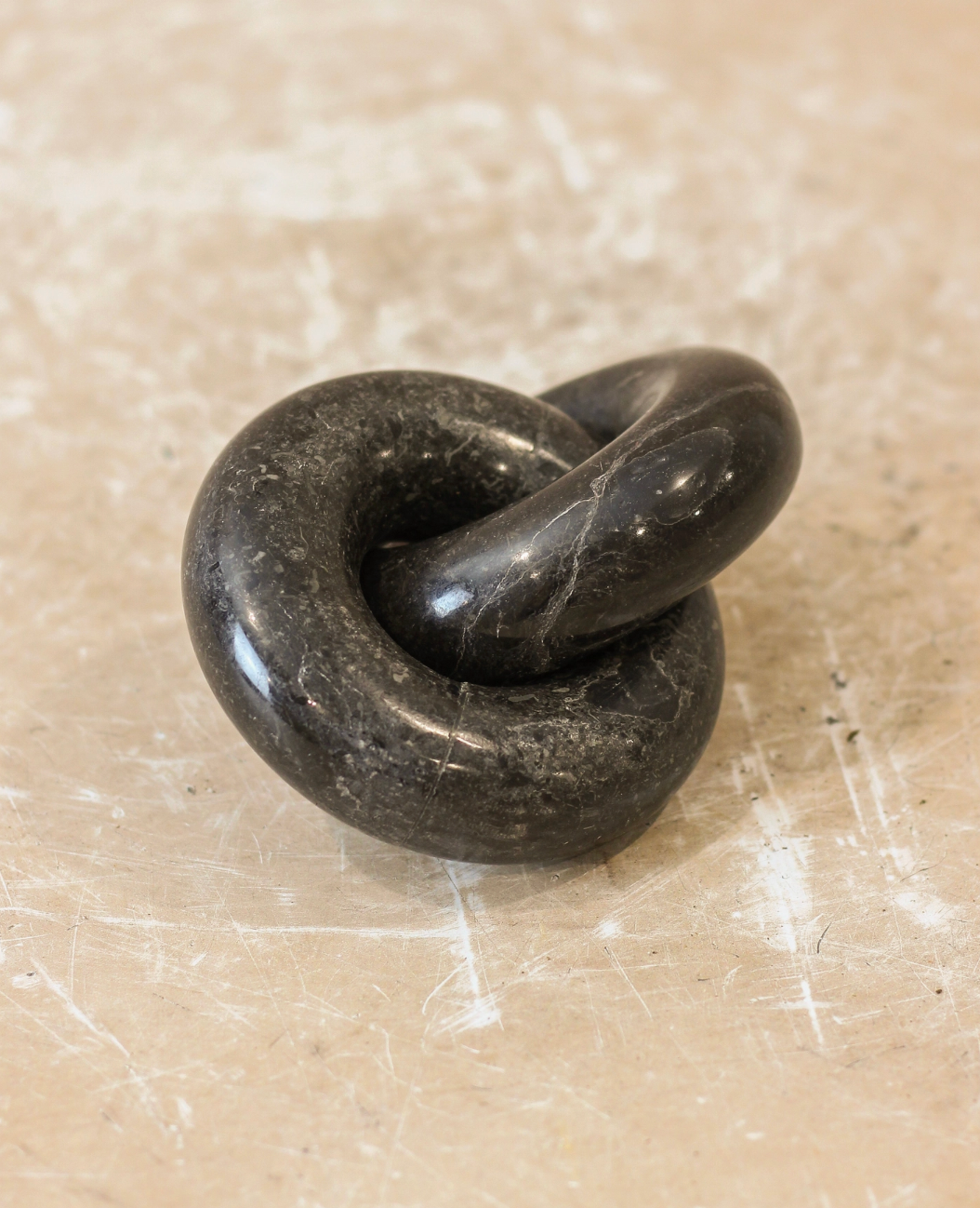 Black stone knot on a beige surface