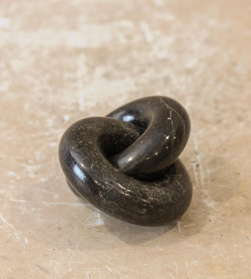 Black stone knot on a beige surface