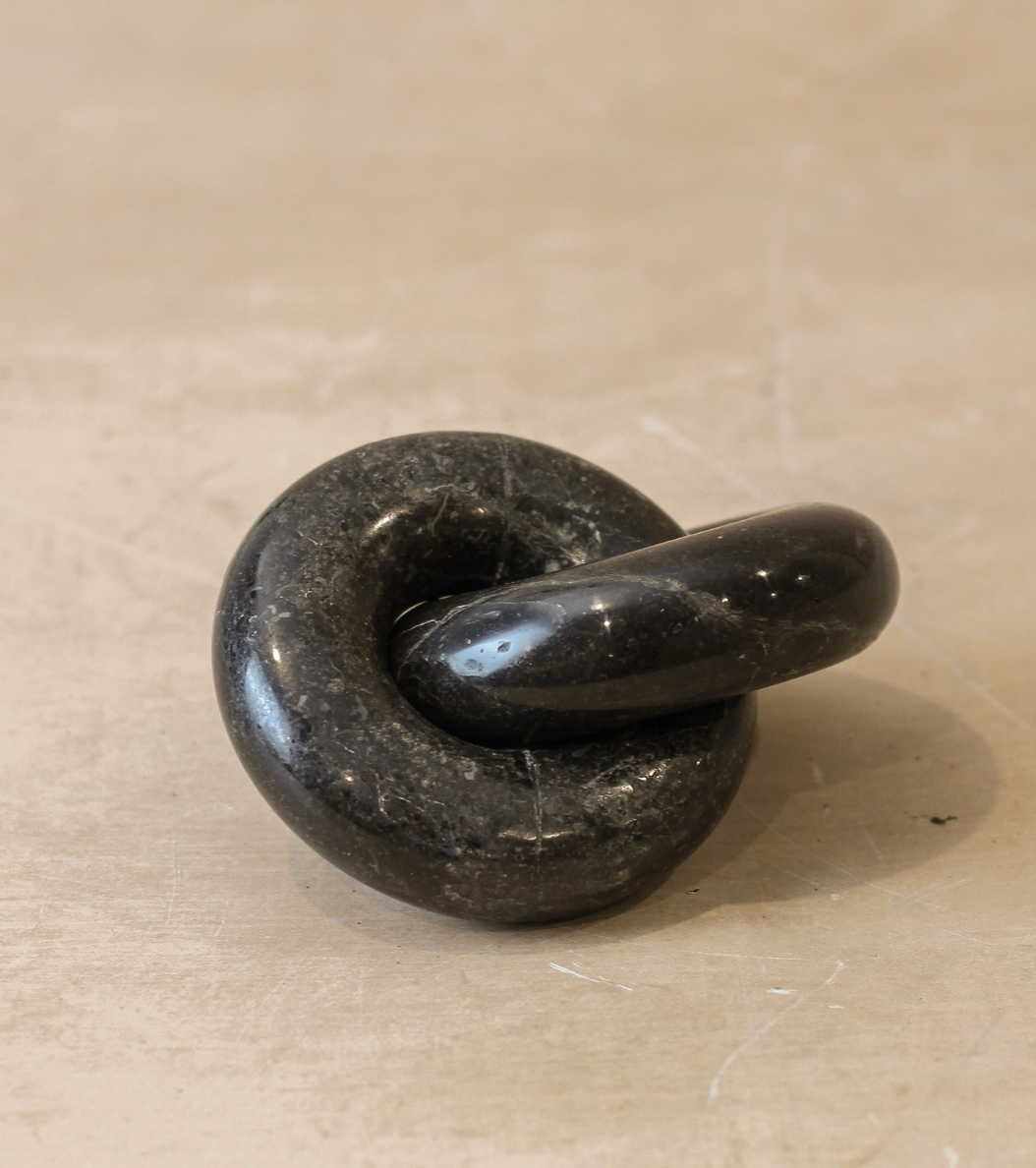 Black stone knot on a beige surface