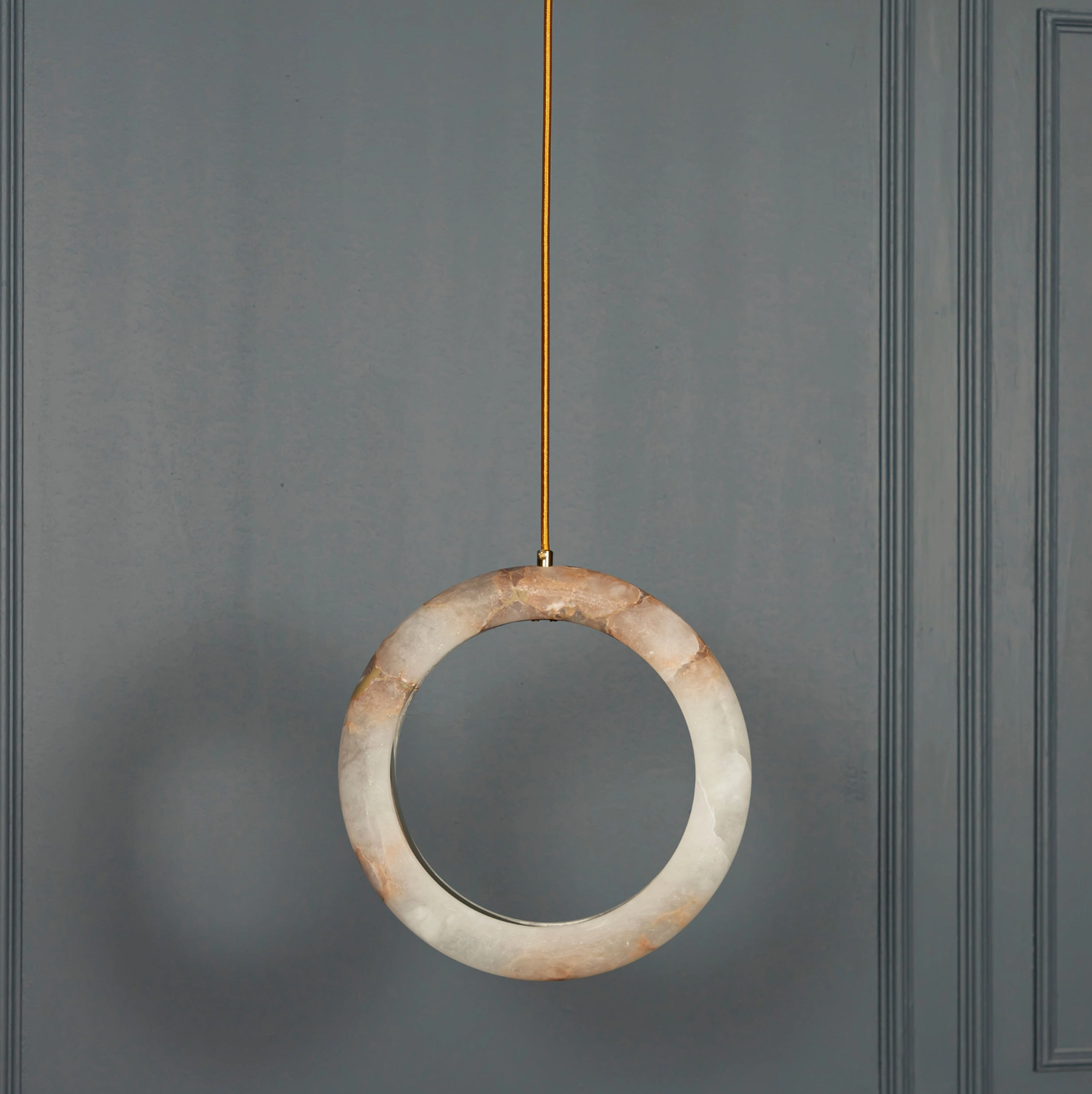 Round pendant light hanging against a gray wall
