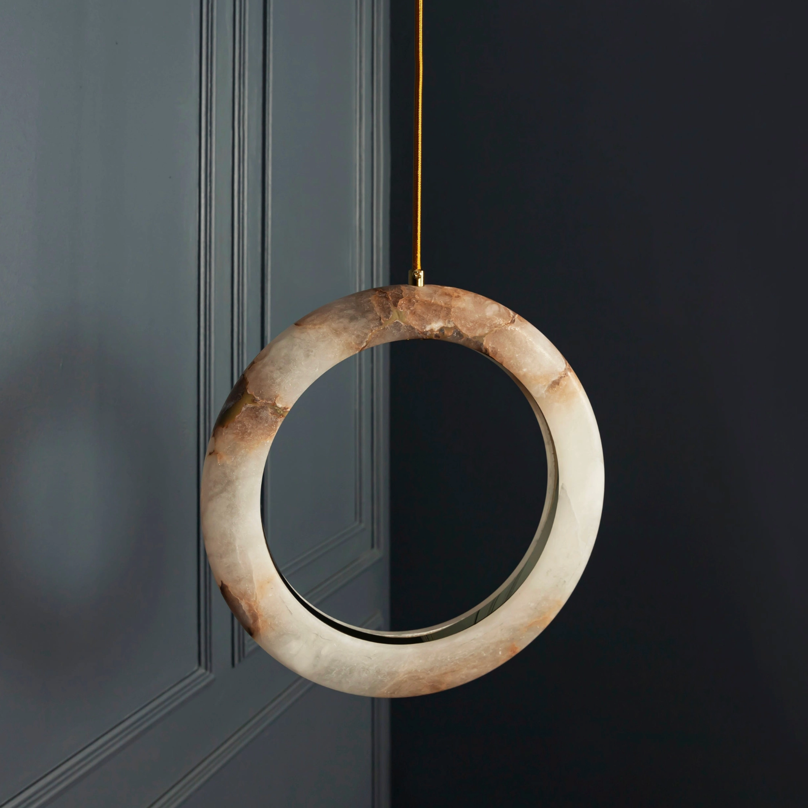 Decorative circular mirror hanging on a dark wall