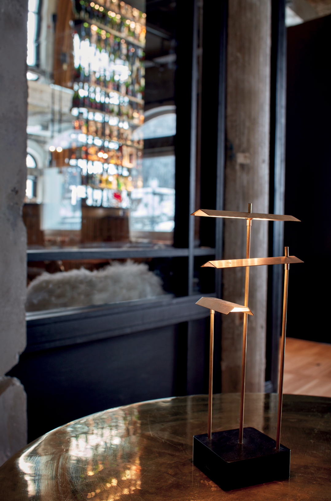 Gold decorative stand on a reflective surface with blurred interior background