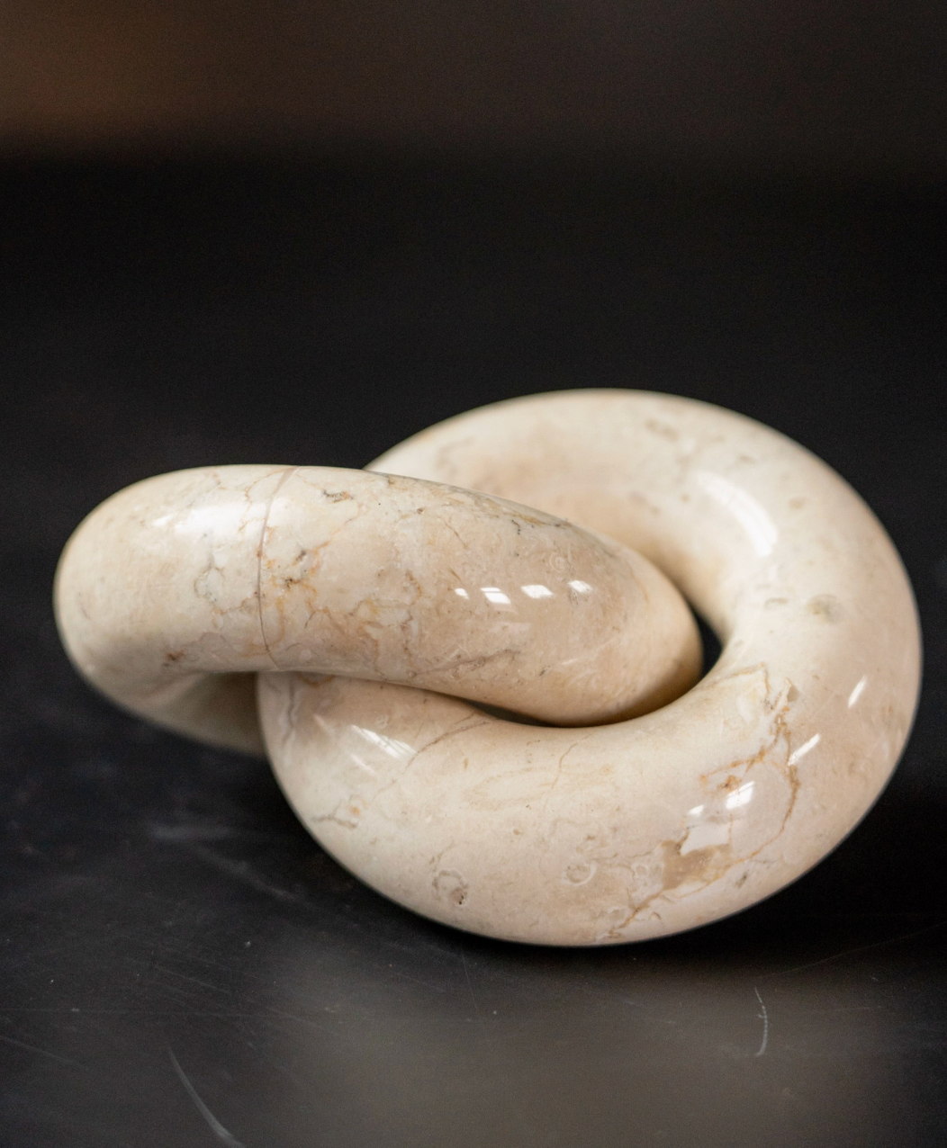 White stone knot sculpture on a dark background