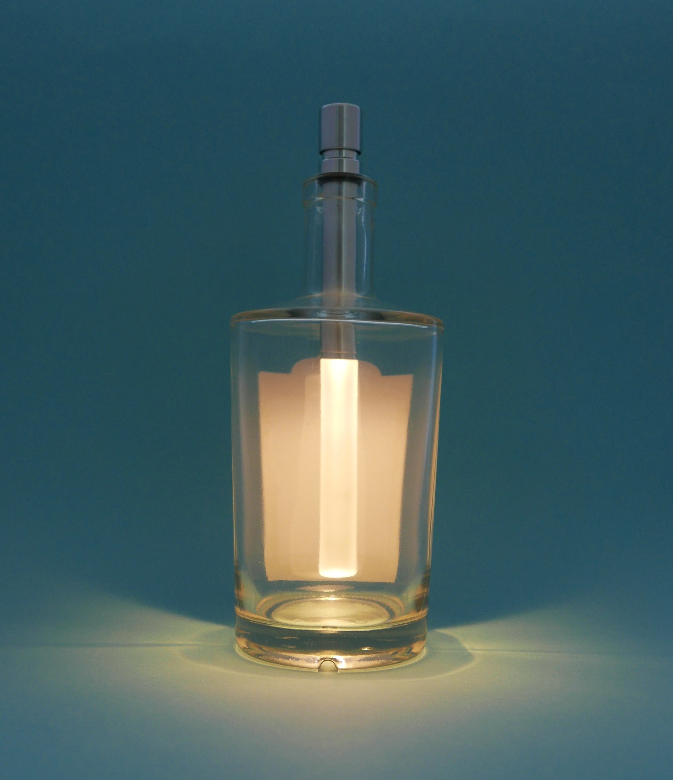 Glass bottle with a light inside on a blue background