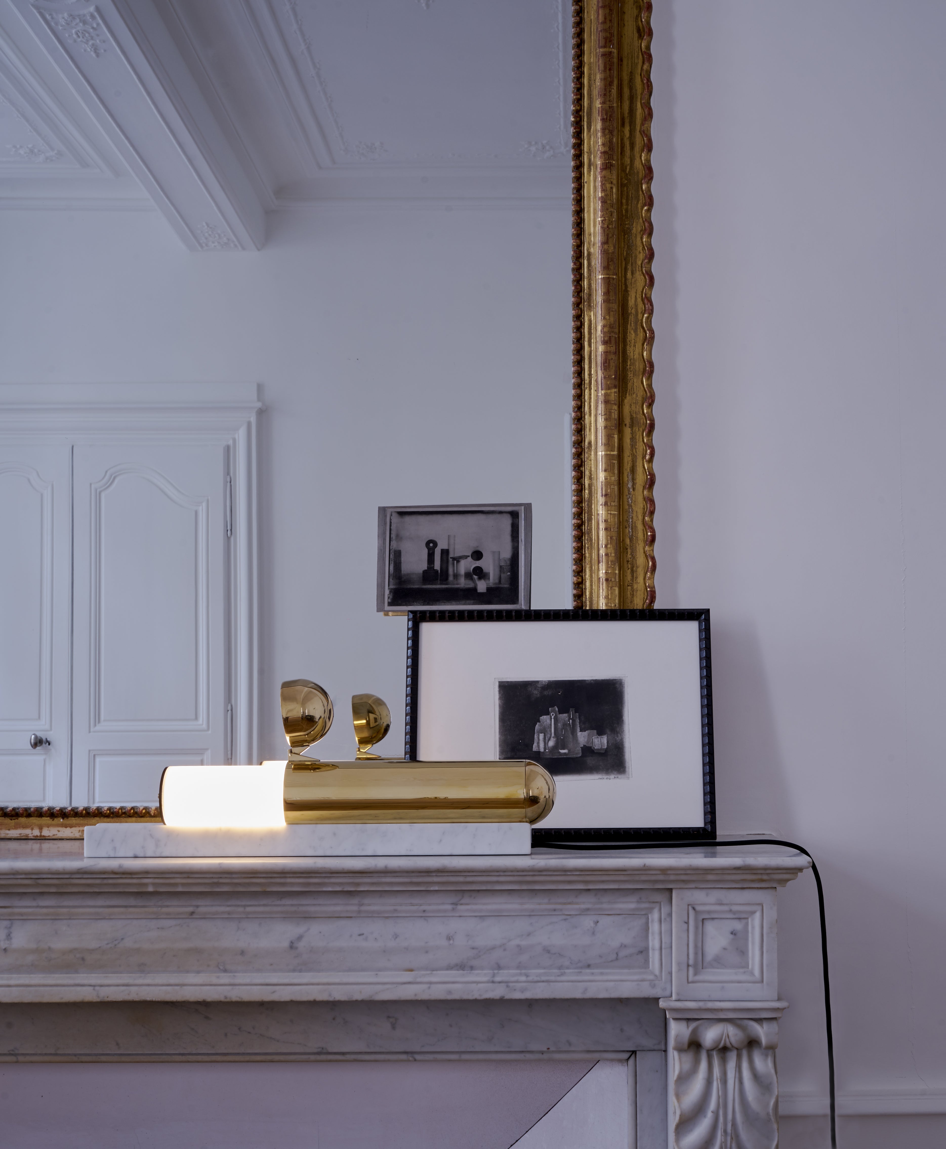 Decorative items on a marble surface with a large mirror in the background