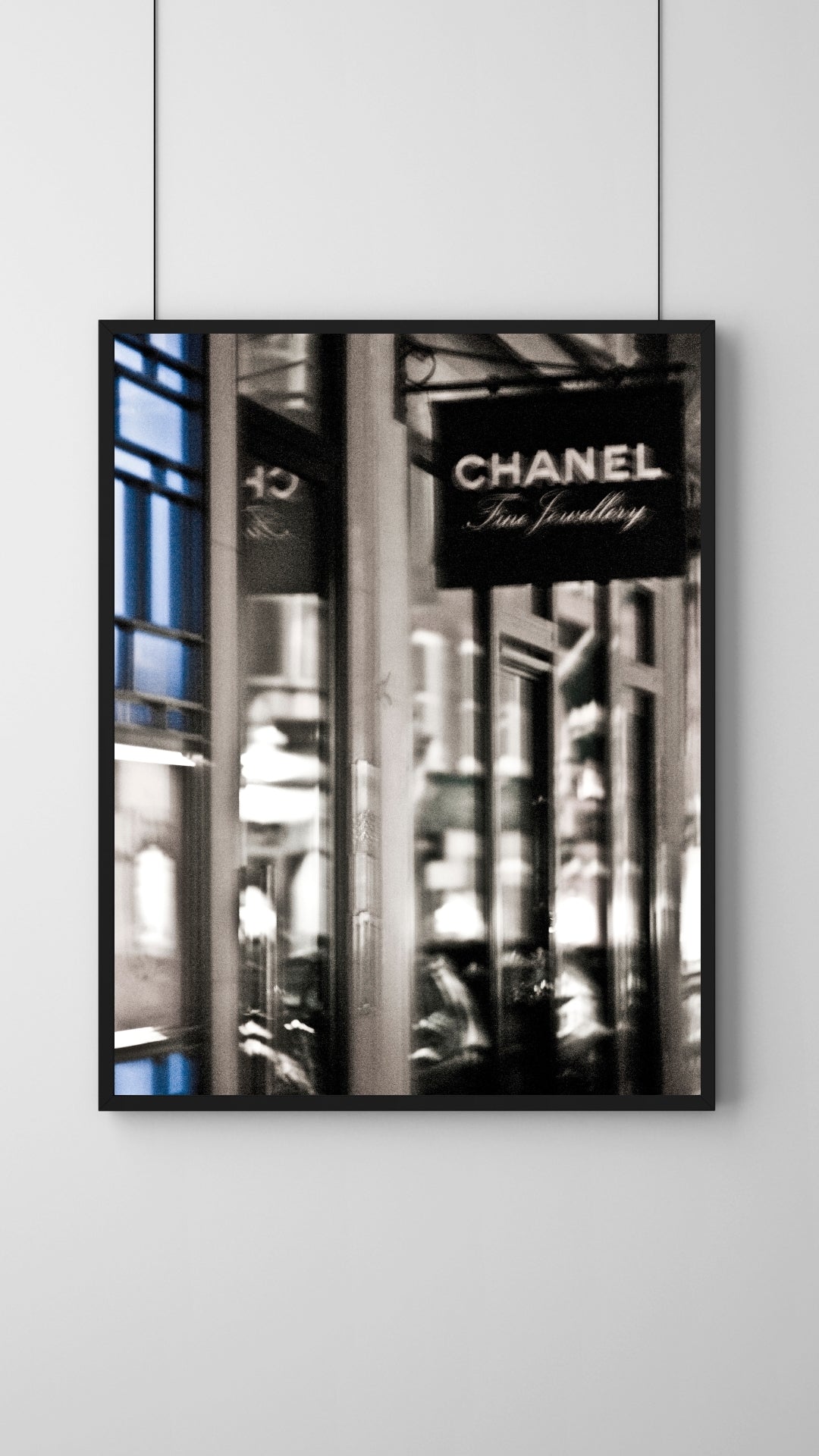 Framed photograph of a Chanel store sign on a city street with a black border.