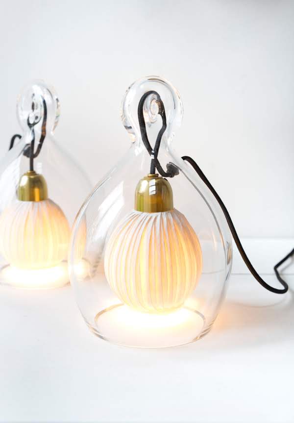 Two glass pendant lights with gold bulbs on a white background