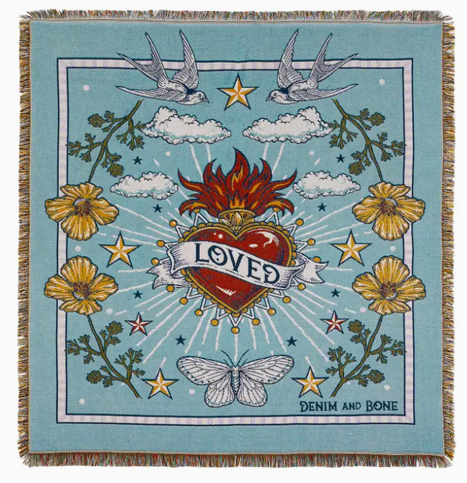 Decorative blanket with heart design, flowers, and birds on a blue background