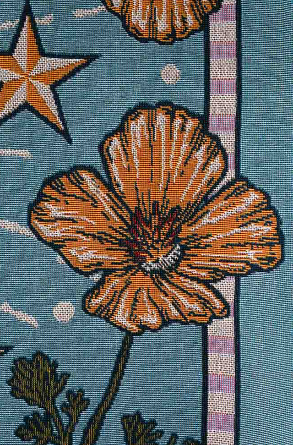 Close-up of a floral patterned fabric with orange flowers and a star on a blue background.