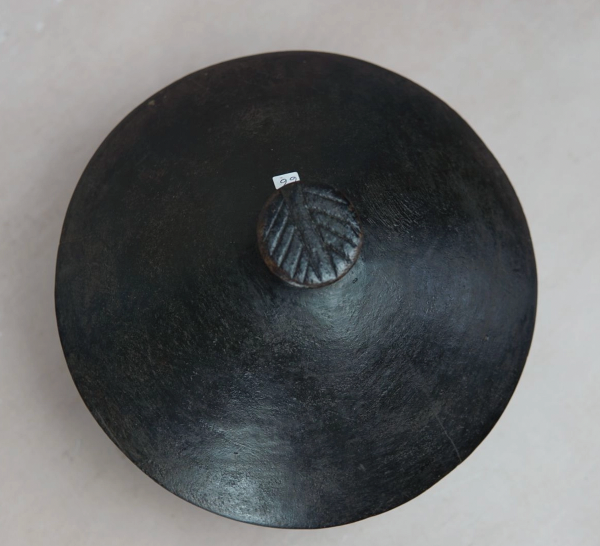 Black ceramic dish with lid on a light gray background