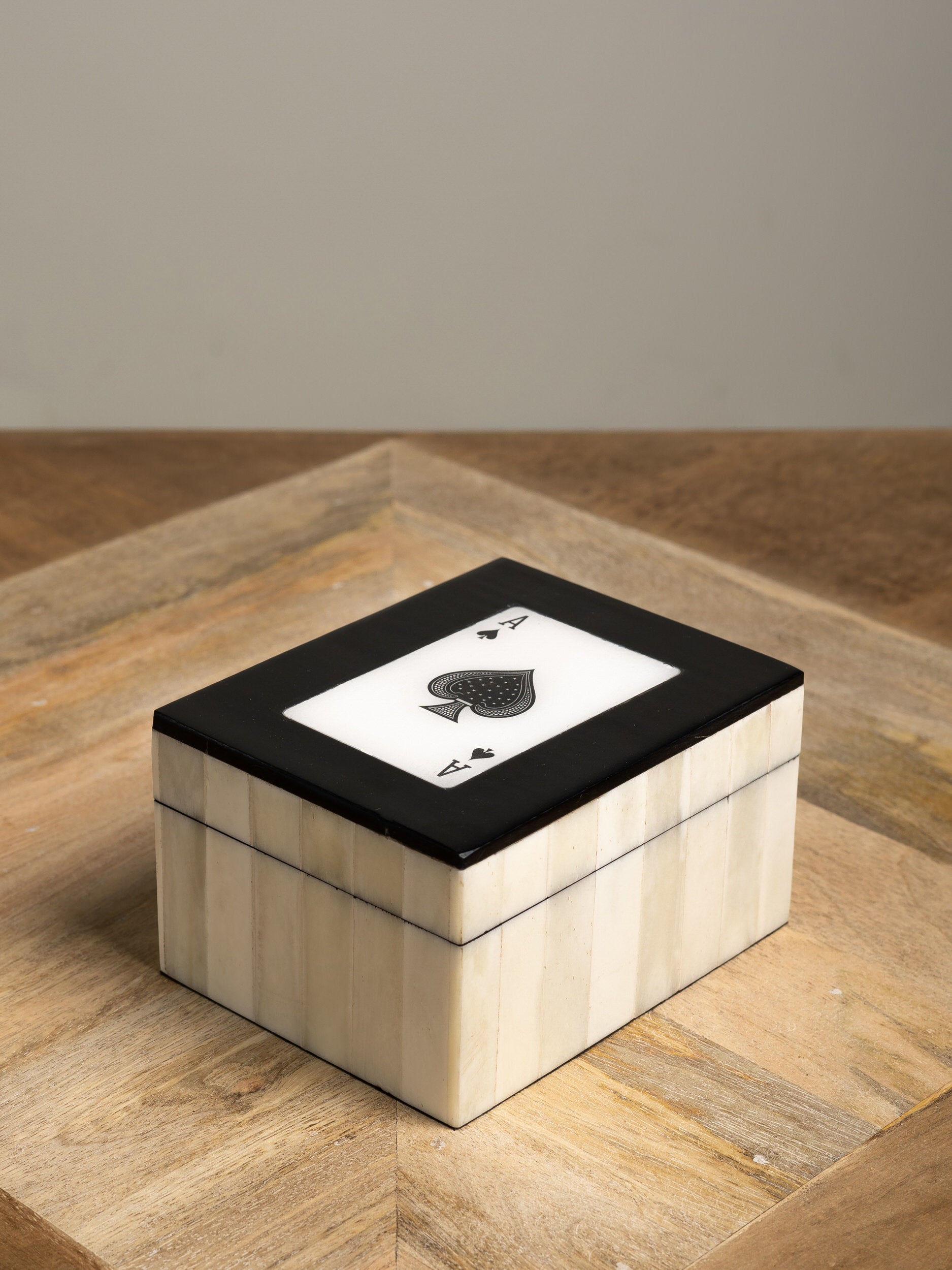 Decorative box with a playing card design on a wooden surface