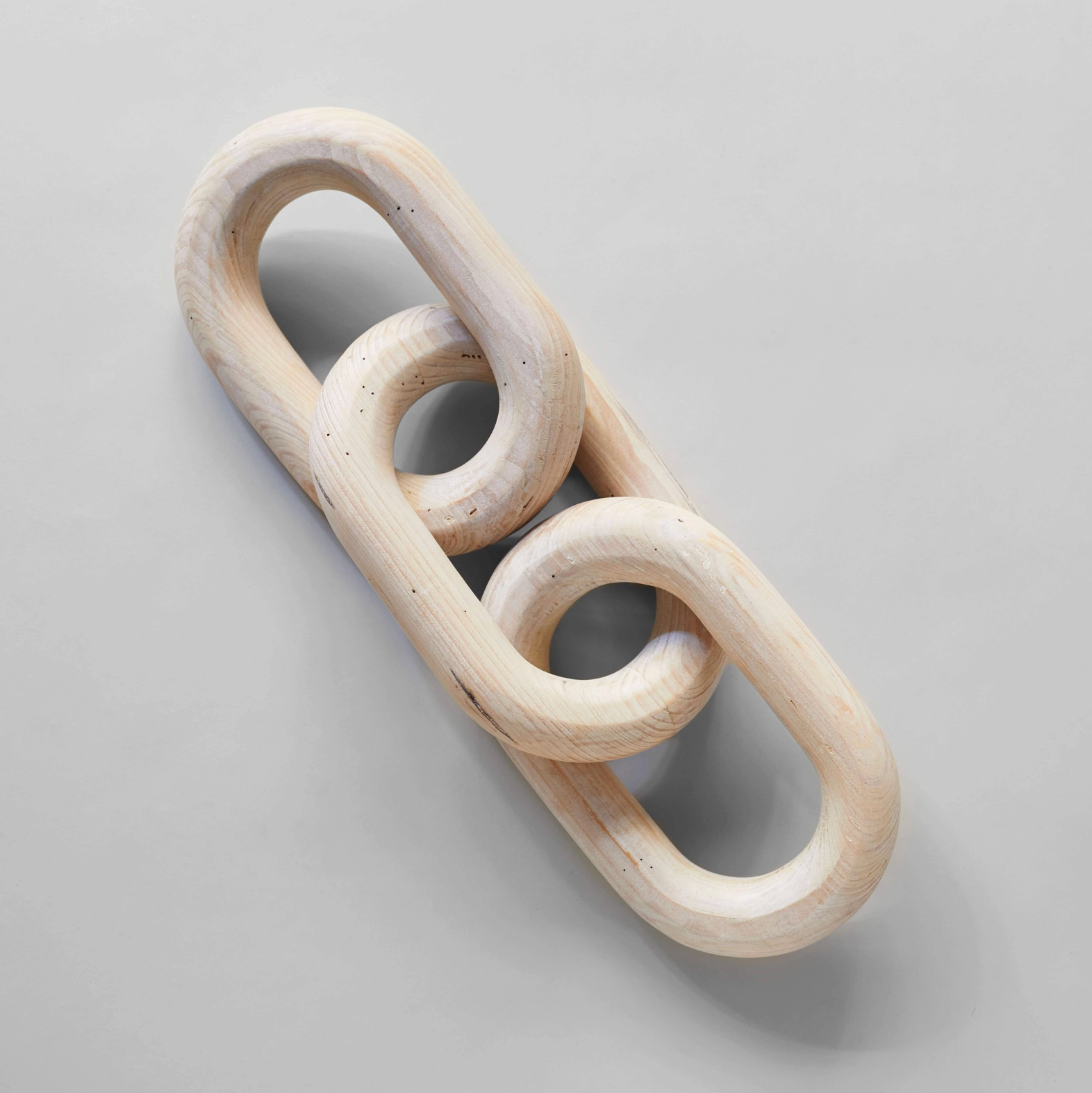 Wooden toy with interlocking rings on a gray background