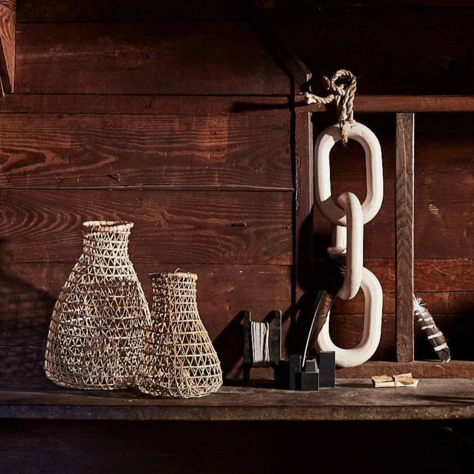 Decorative vases and chain on a wooden shelf with a rustic background