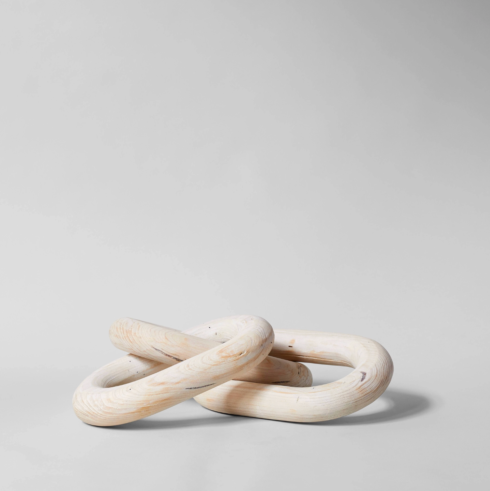 Two wooden rings stacked on a light gray background