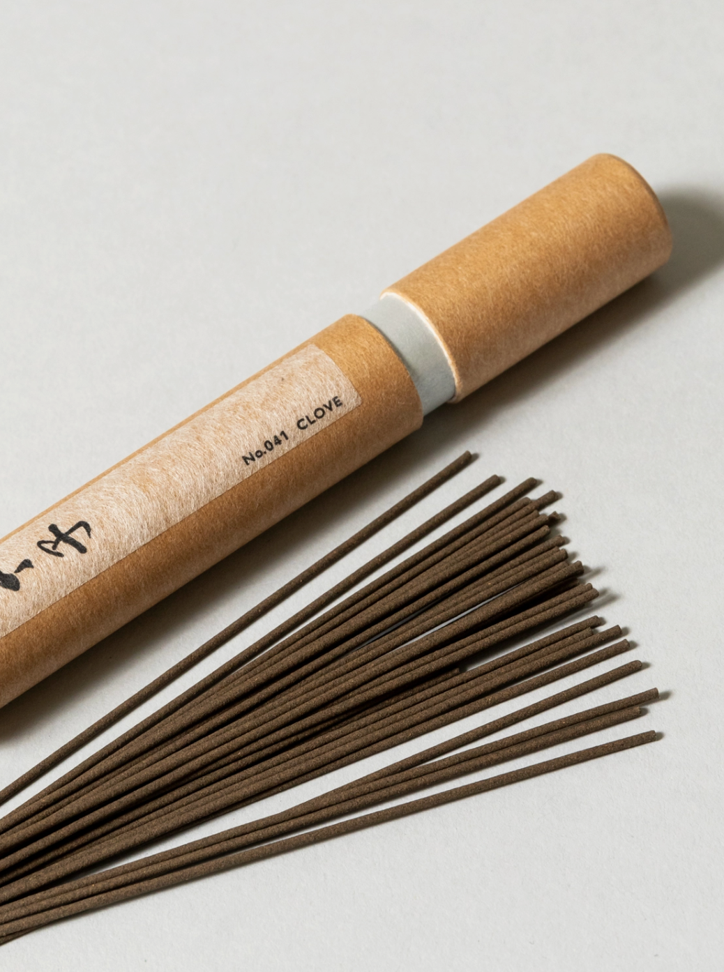 Incense sticks with a cardboard tube on a light background