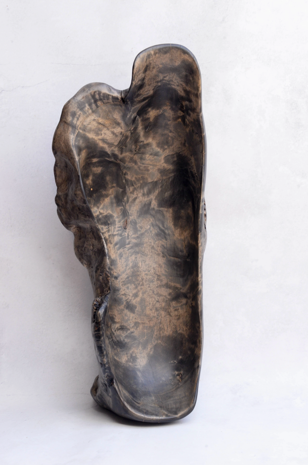 Brown stone sculpture of a foot on a white background