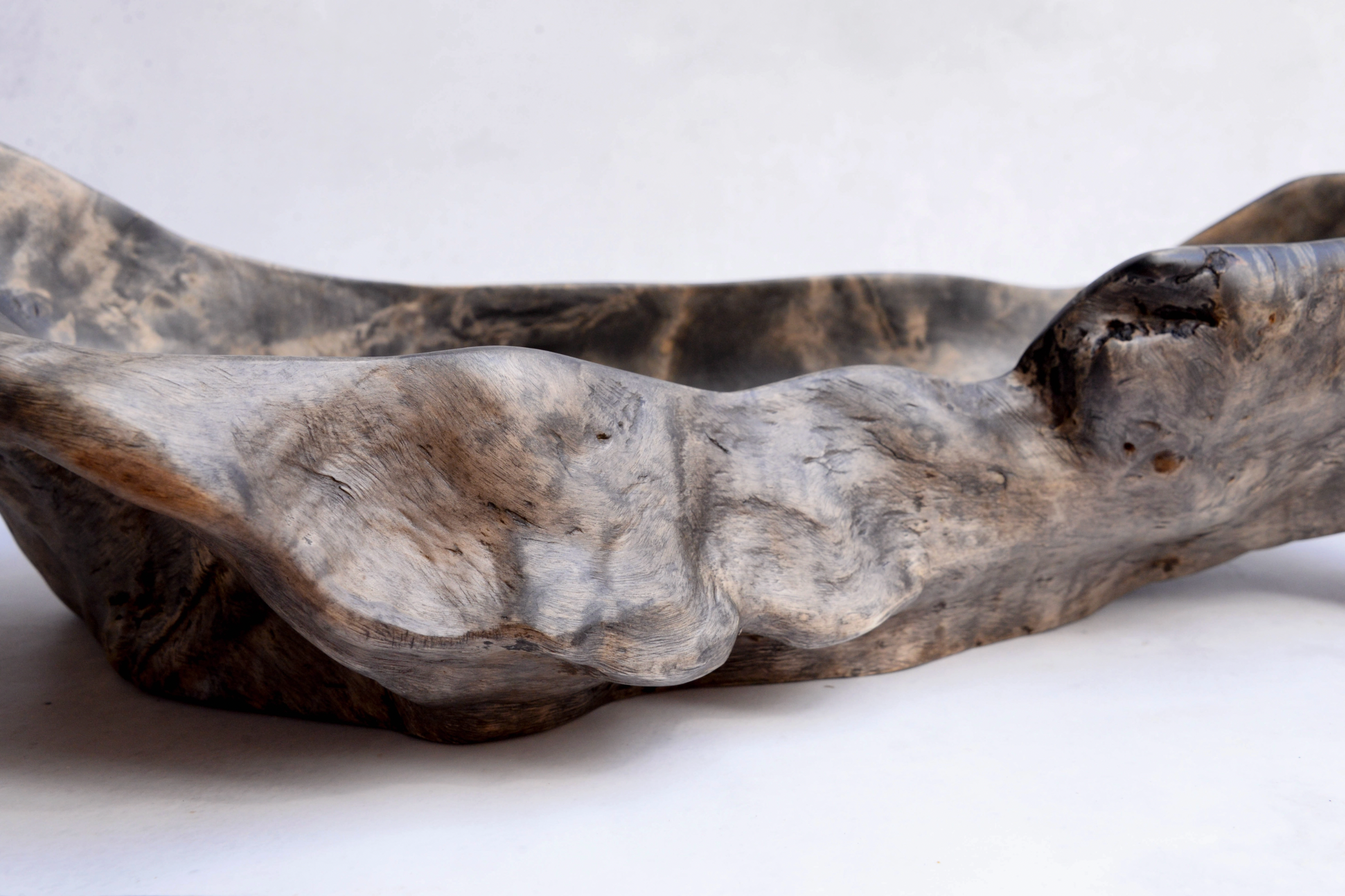 Wooden bowl with a natural, textured surface on a white background