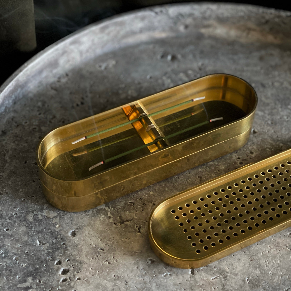 Brass Incense Burner . Brass kitchen tool set on a textured surface