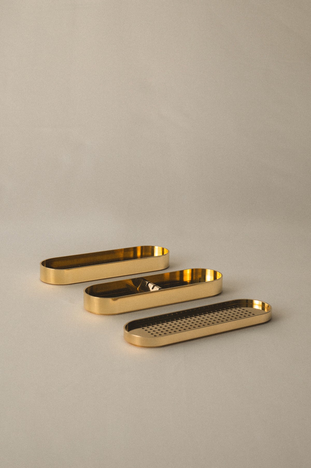 Brass Incense Burner .Three gold metal trays of different shapes on a beige background