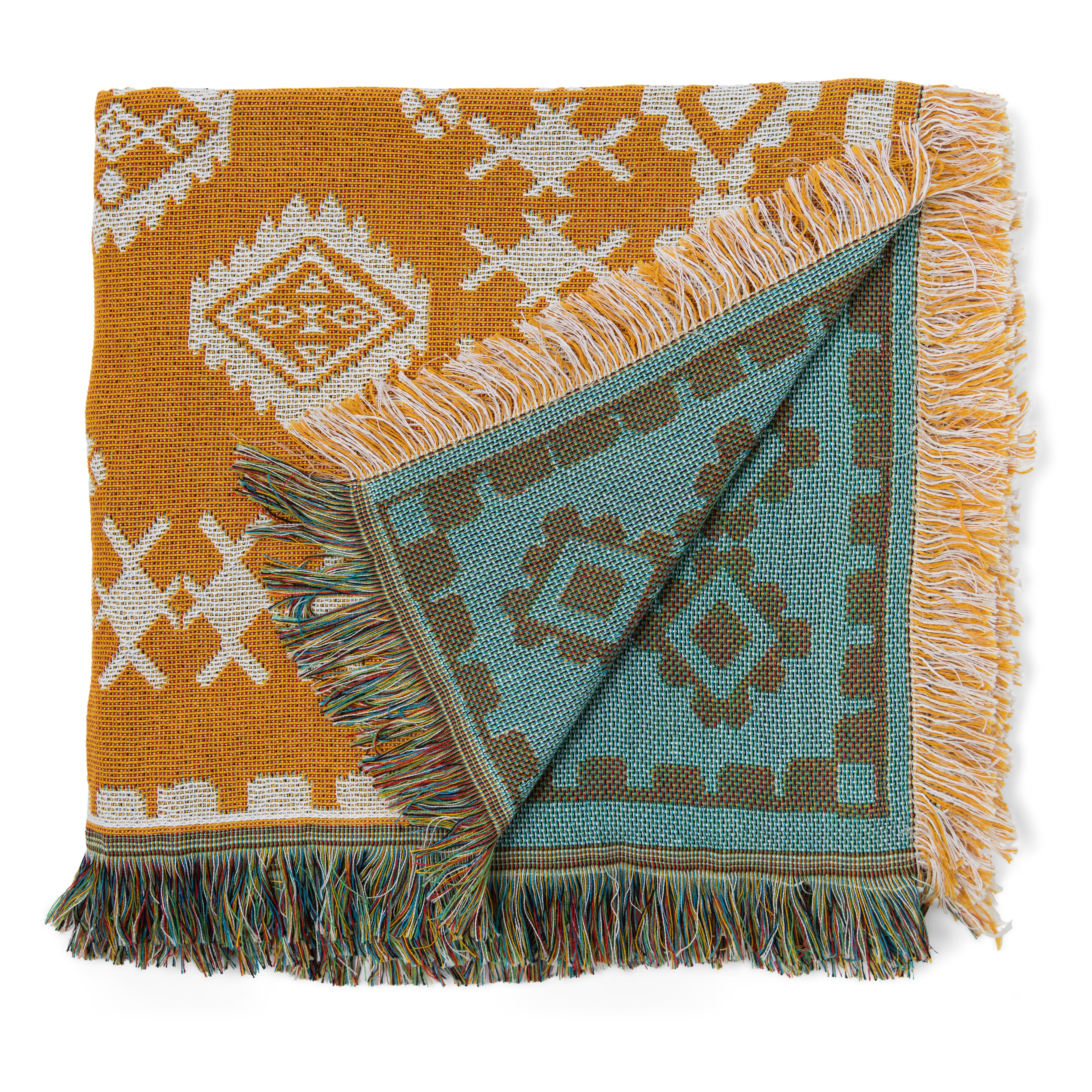 Two patterned blankets, one orange and white, the other blue and brown, on a white background.