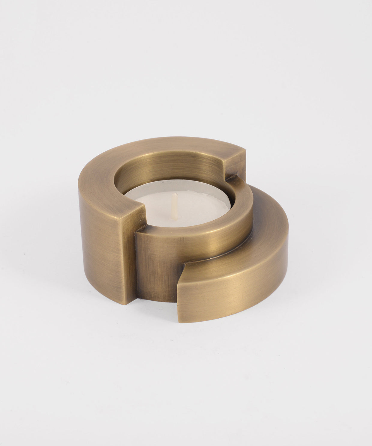 Brass candle holder with a candle on a white background