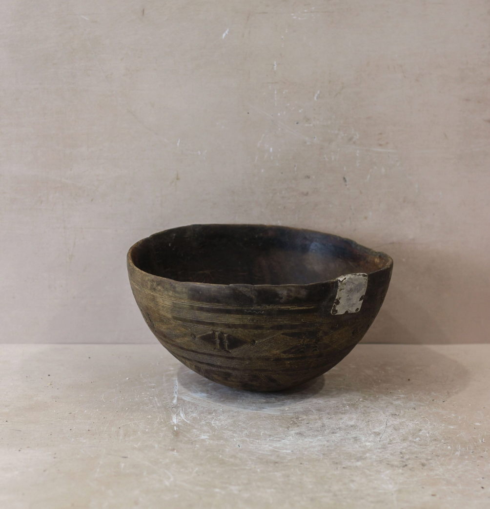 Black ceramic bowl on a light gray surface with a neutral background