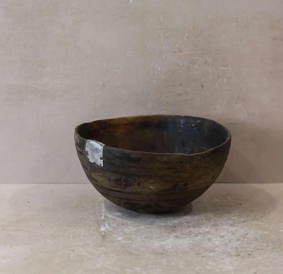 Wooden bowl on a light gray surface with a neutral background