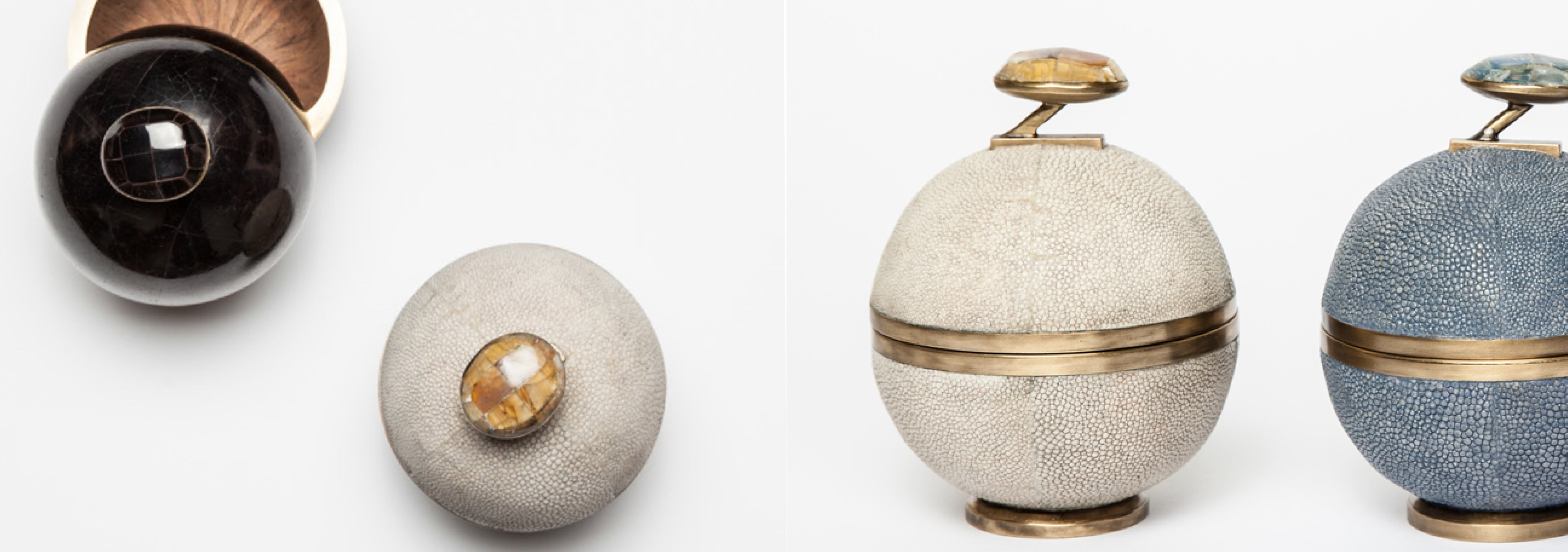 Set of decorative spherical containers with textured surfaces and metallic accents on a white background