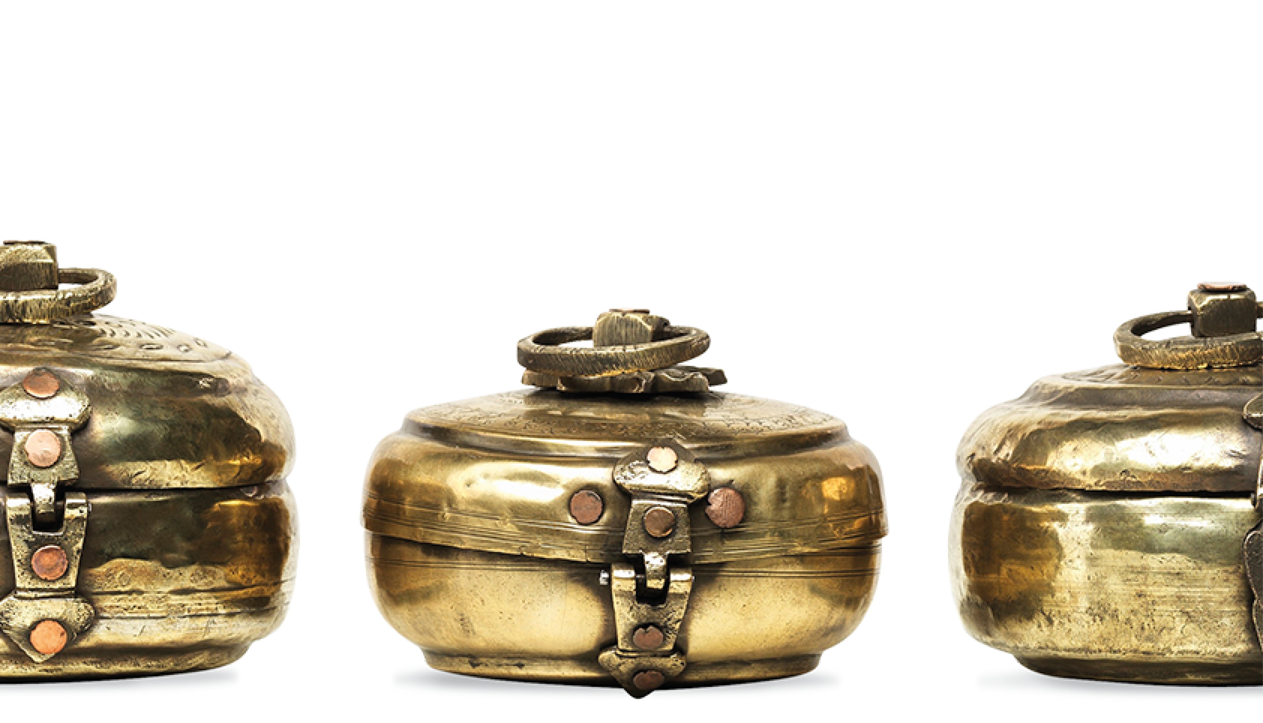 Three brass lockets on a white background