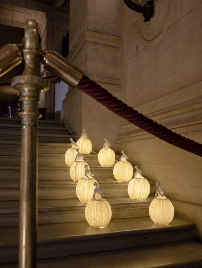 Decorative string lights on a staircase with a classical architecture background