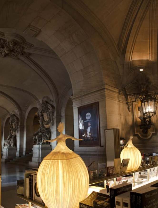 Decorative lamps in a museum setting with stone arches and sculptures.