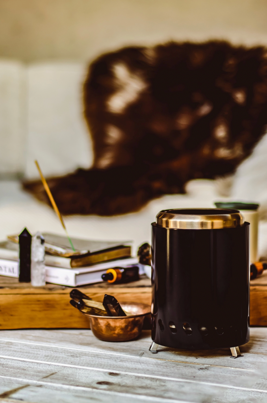 Black metal stove on a wooden surface with books and a candle in the background