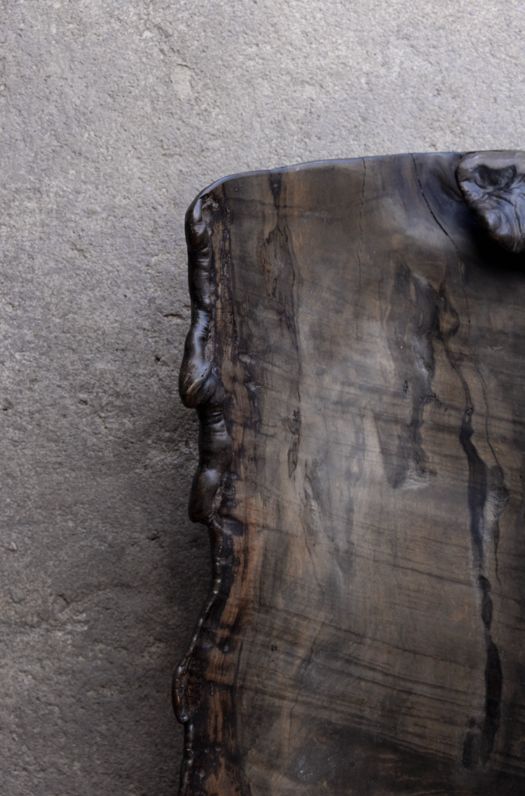 Close-up of a dark wood cutting board on a gray surface