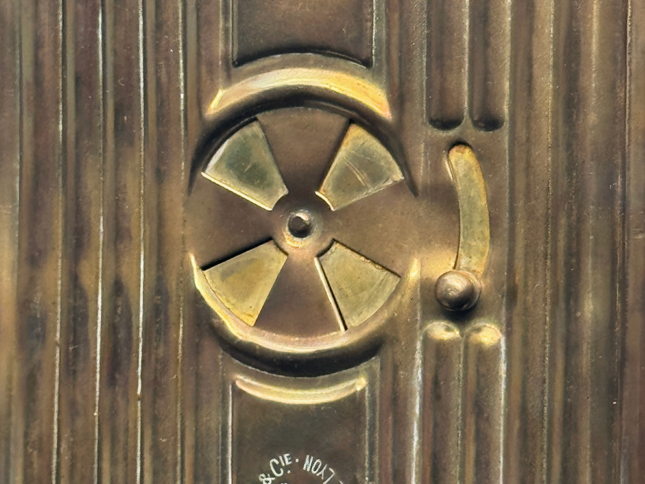 Close-up of a bronze or brass mechanical component with a ribbed background