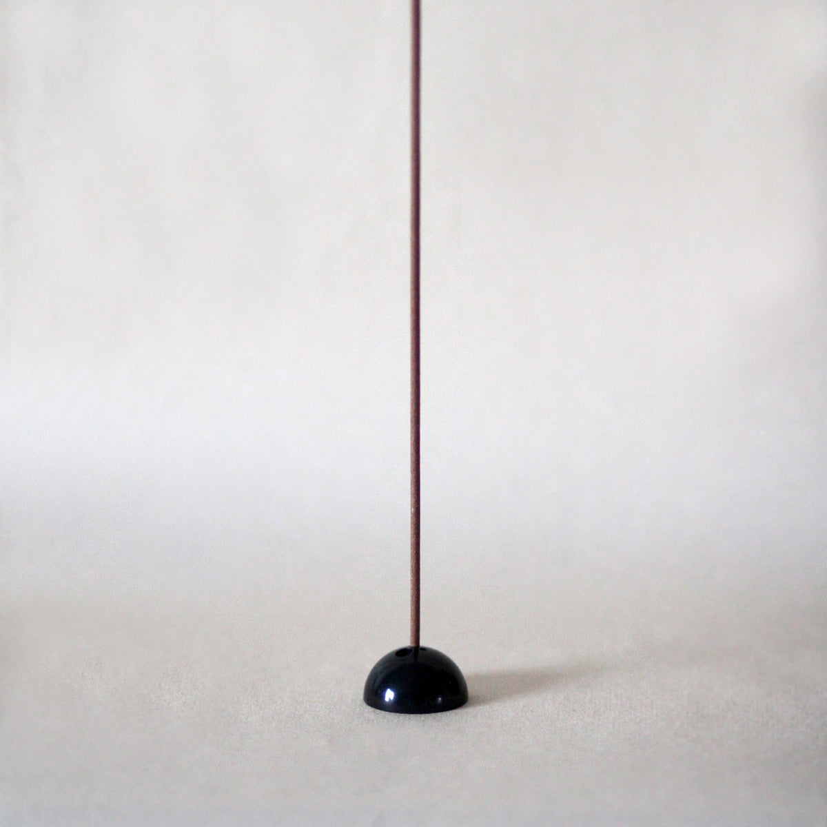black brass dome incense stick holder with three holes on a neutral background