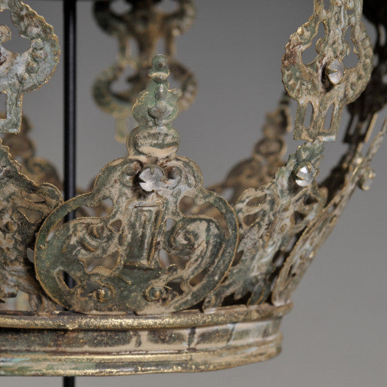 Decorative metal crown with intricate designs on a gray background