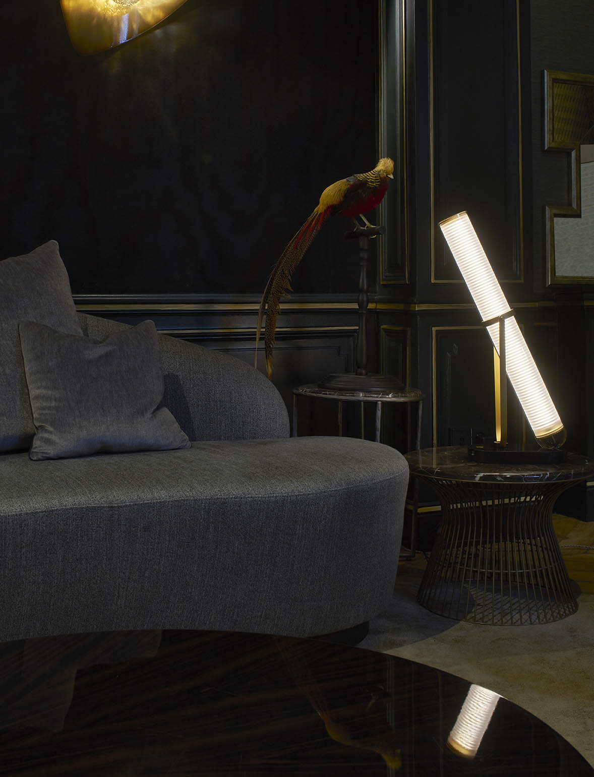 Modern living room with a gray sofa, decorative lamp, and abstract wall art.