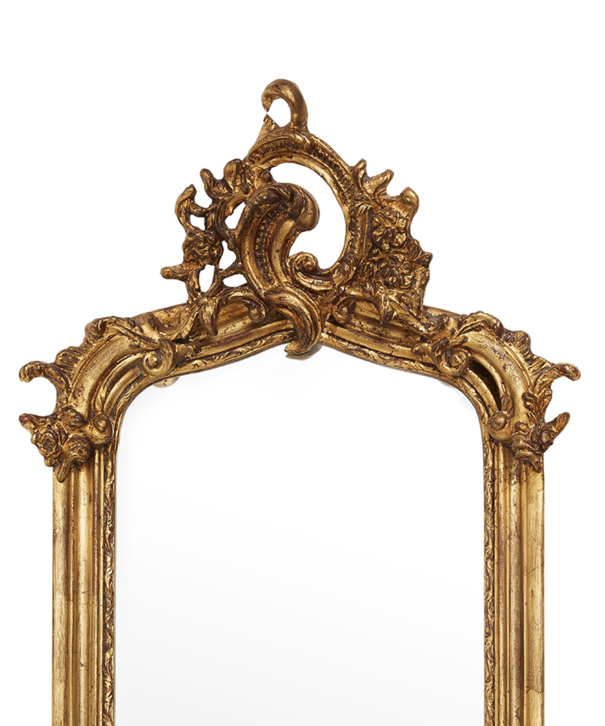 Decorative gold mirror with intricate designs on a white background