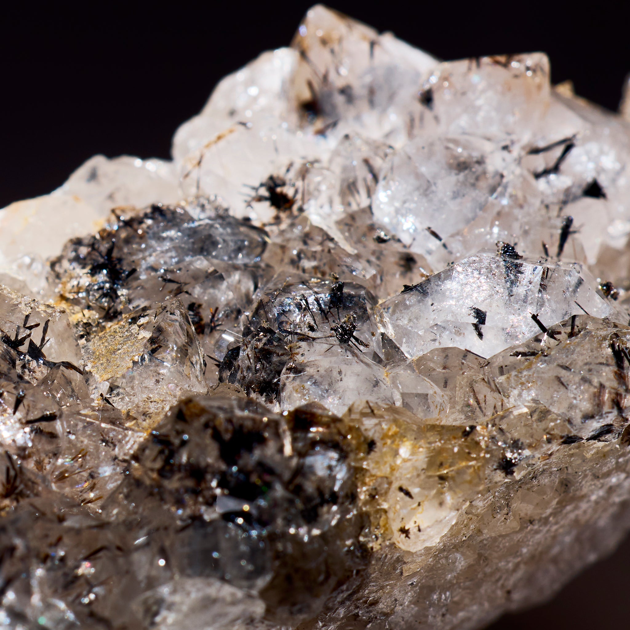 Close-up of a crystal formation with various minerals on a dark background