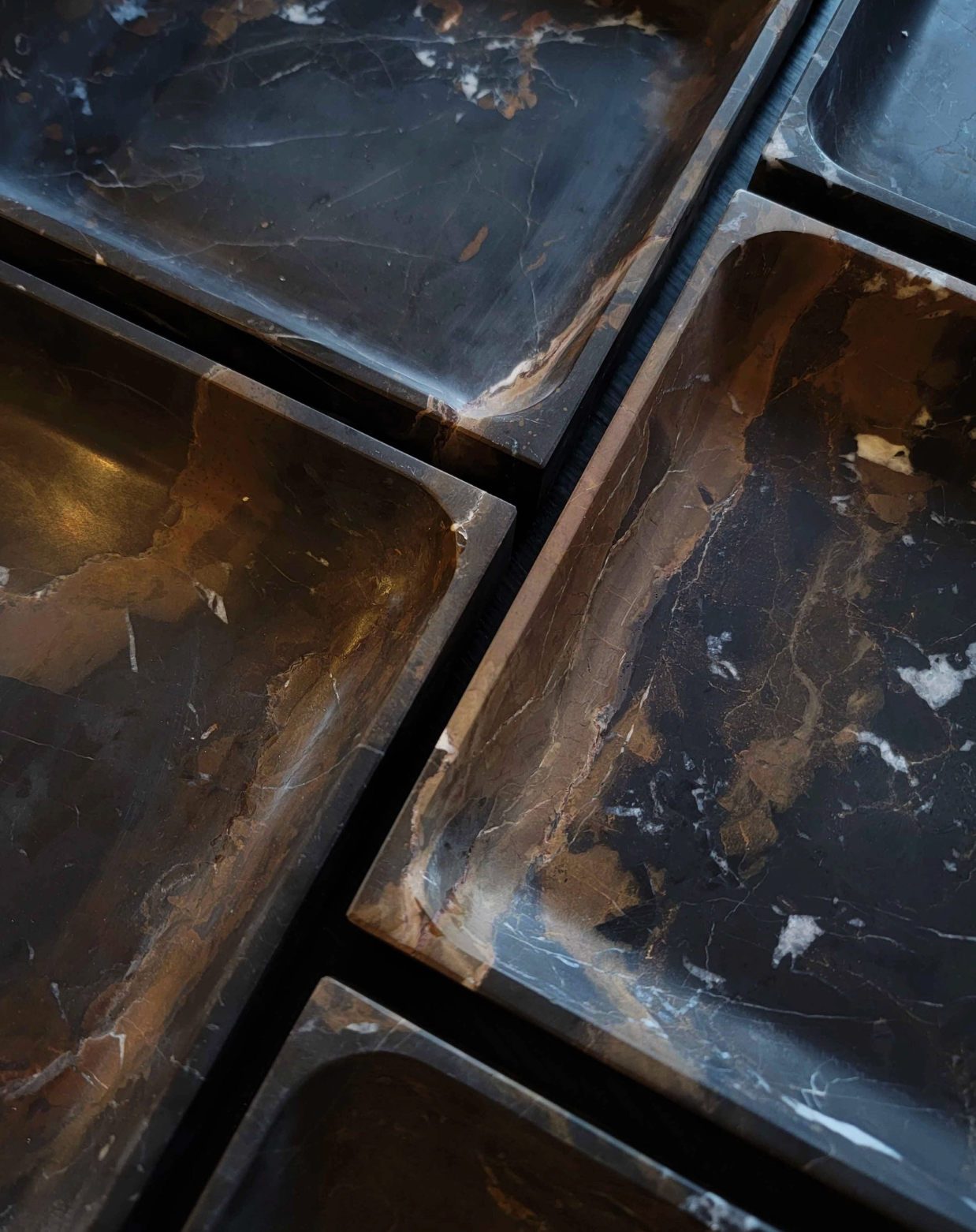 Close-up of dark marble tiles with visible veins and surface imperfections
